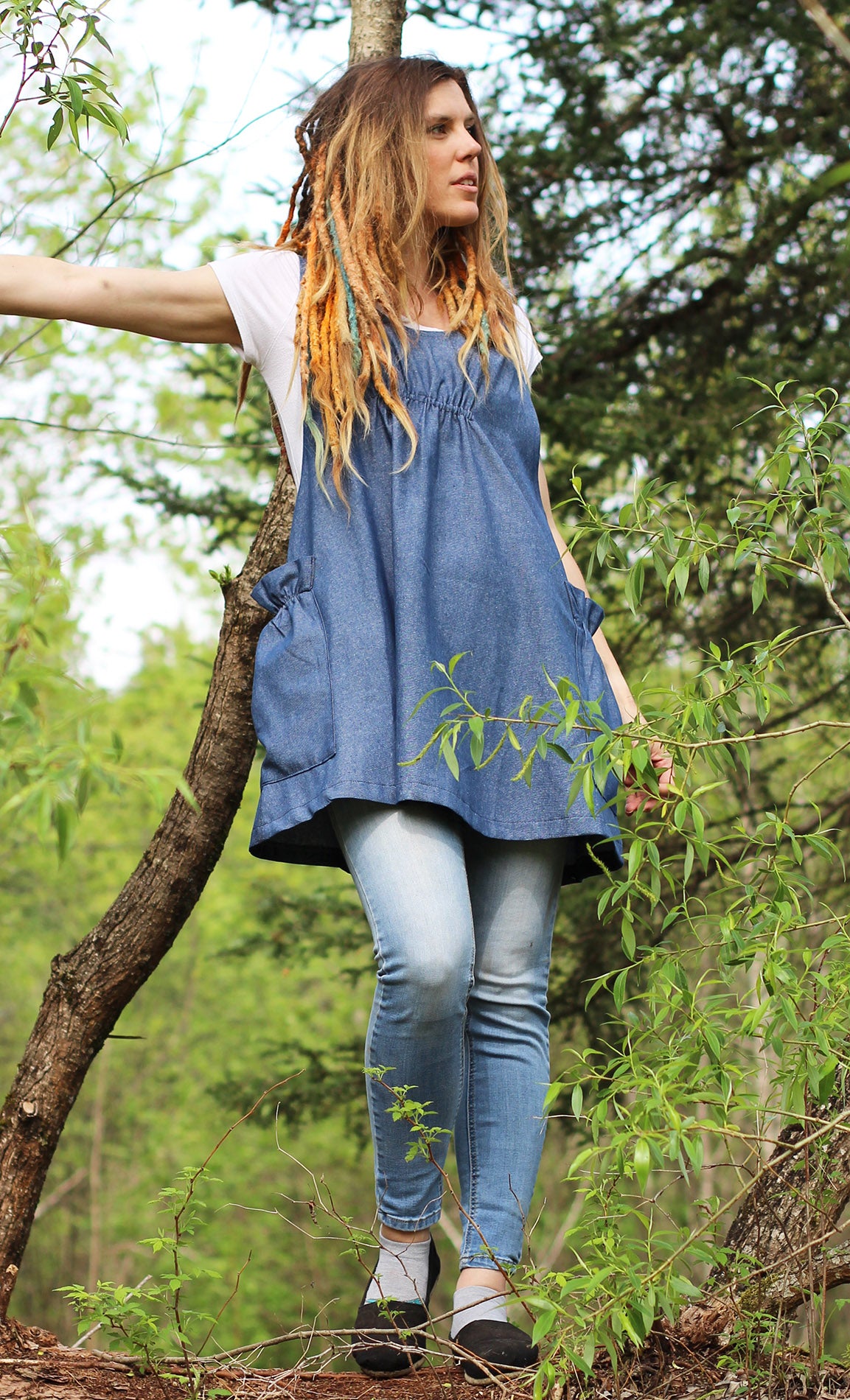 XS-5X Smock #1 in Denim - Front View with model standing on a fallen log, looking off to the side.
