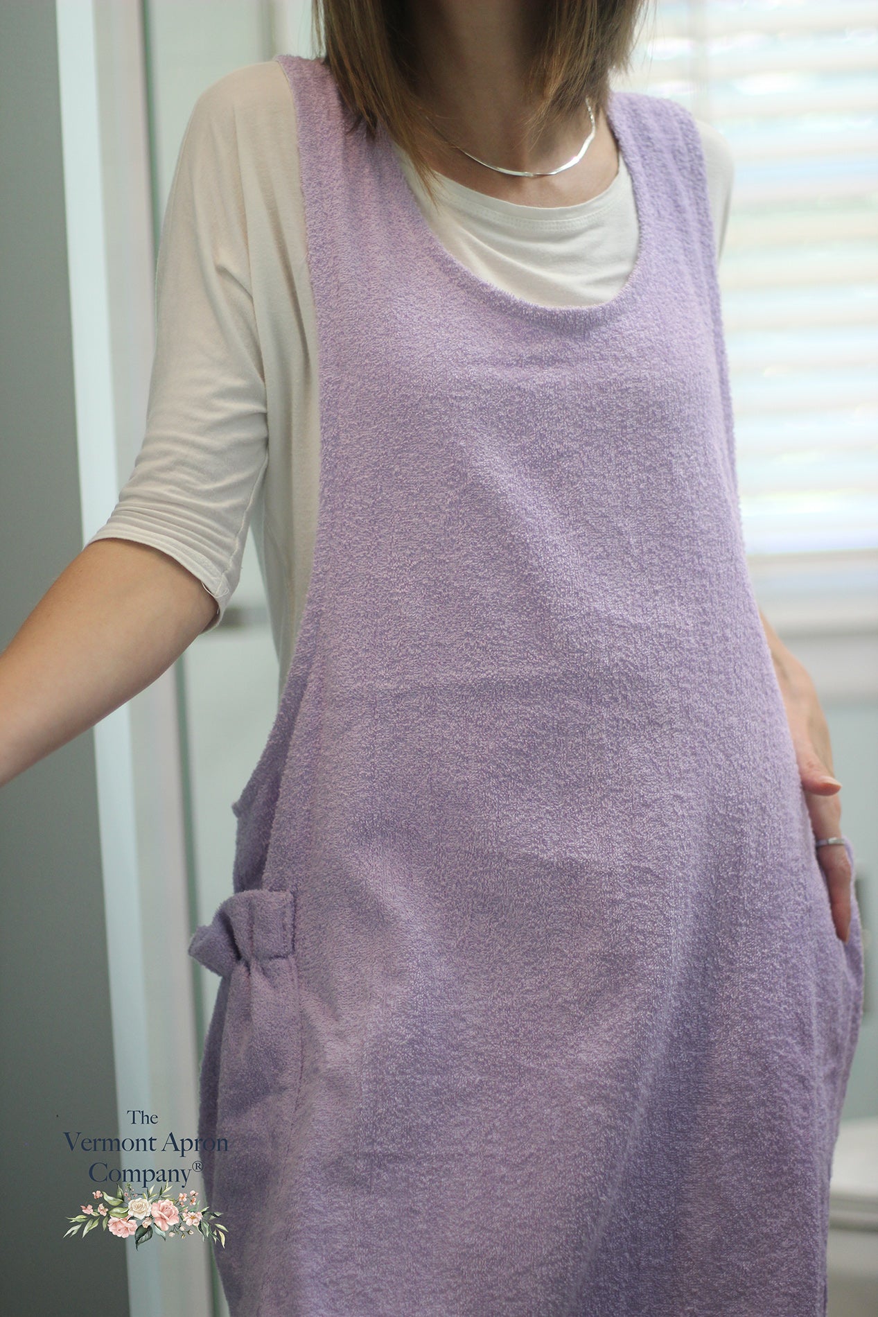 XS-5X Lilac Terry Apron - No Tie Crossback Apron _ The model is showing a close up of the texture of the fabric.